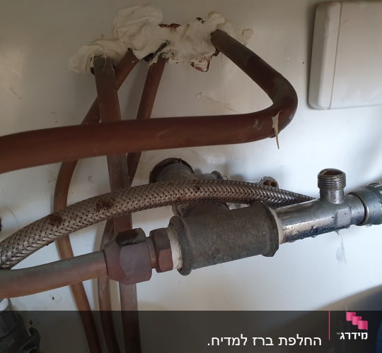צינורות מתכת וברז דולף מתחת לכיור